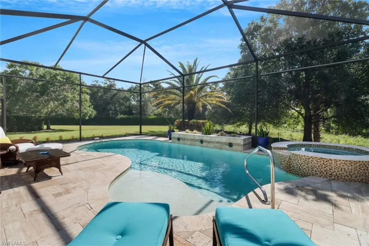 View of pool featuring an in ground hot tub, a patio area, and a lanai