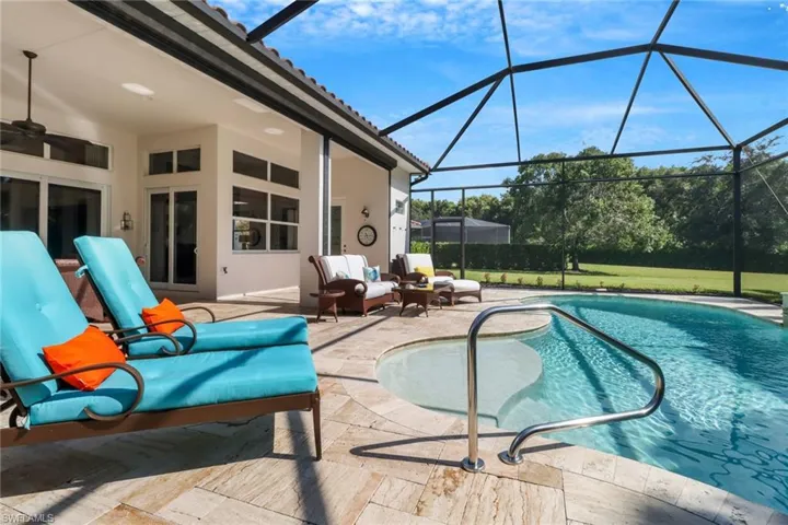 View of swimming pool with a patio, ceiling fan, and glass enclosure