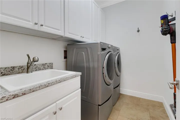 Laundry room featuring cabinets, washer and dryer, and sink