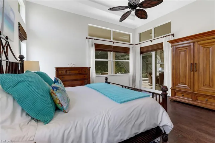Bedroom featuring dark hardwood / wood-style floors, access to exterior, and ceiling fan