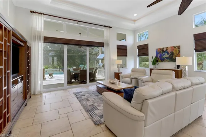 Living room featuring a high ceiling, ceiling fan, and light tile patterned floors