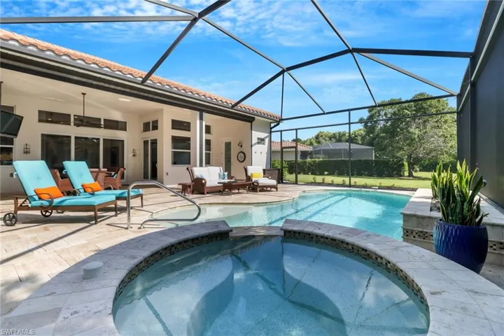 View of pool featuring a patio area, ceiling fan, an in ground hot tub, and glass enclosure