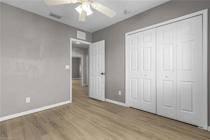 Unfurnished bedroom with light wood-style floors, a ceiling fan, and a closet