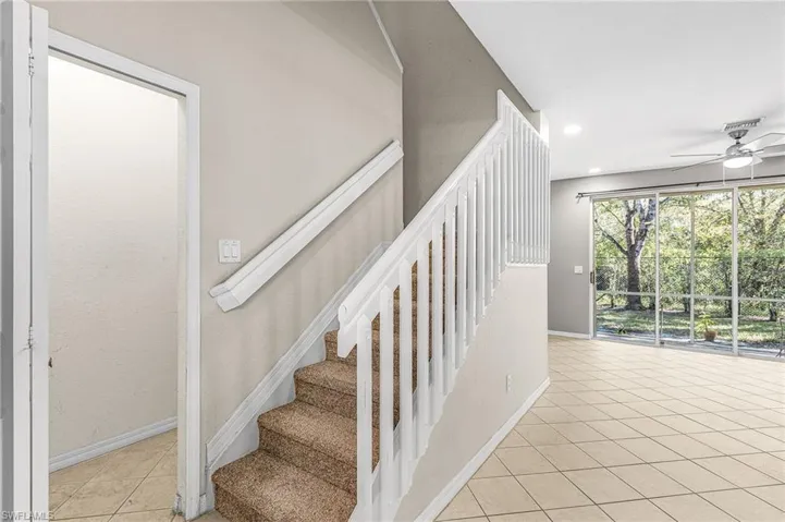 Staircase with tile patterned flooring, ceiling fan, and recessed lighting