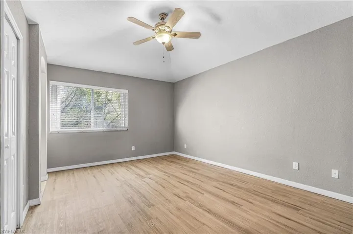 Unfurnished bedroom featuring light wood-style floors, a ceiling fan, a textured wall, and a closet