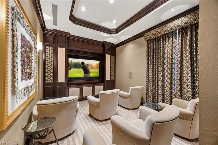 Cinema room with a raised ceiling, ornamental molding, and recessed lighting