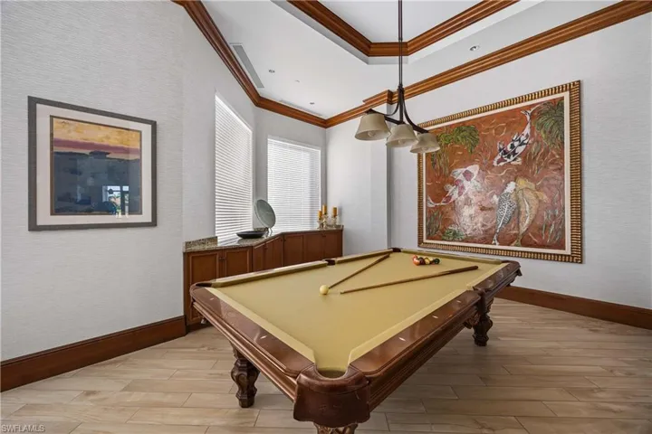 Rec room with light wood-type flooring, ornamental molding, and billiards table