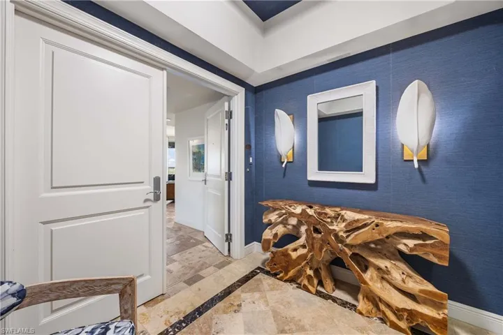 Hall featuring inlaid floor details and baseboards