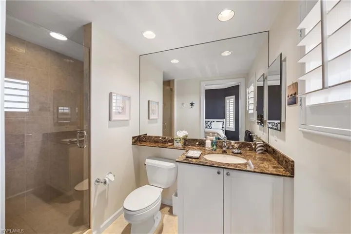 Ensuite bathroom with vanity, recessed lighting, a shower stall, and light tile patterned floors