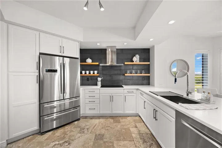 Kitchen with white cabinetry, open shelves, appliances with stainless steel finishes, recessed lighting, and exhaust hood
