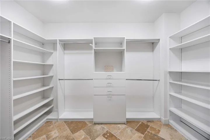 Walk in closet featuring stone tile flooring