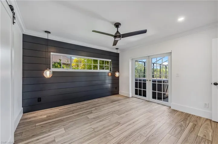 featuring french doors, wood tile finished floors, ceiling fan, and ornamental molding