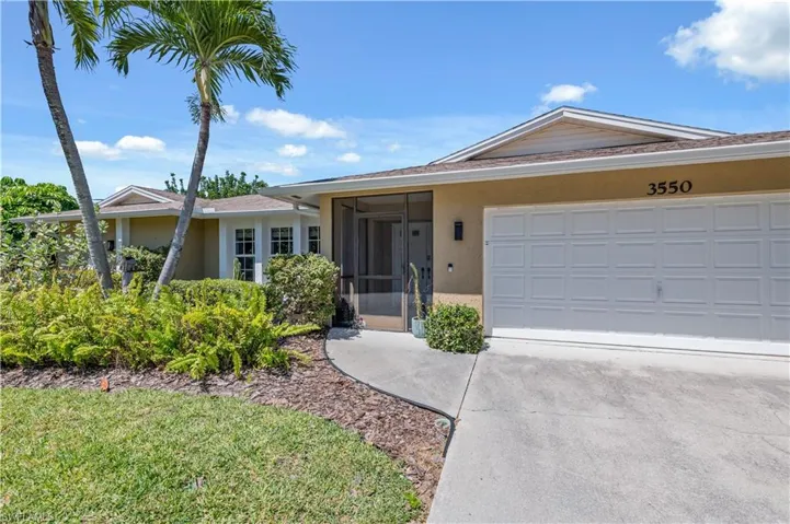 Ranch-style home with stucco siding, driveway, and a sunroom