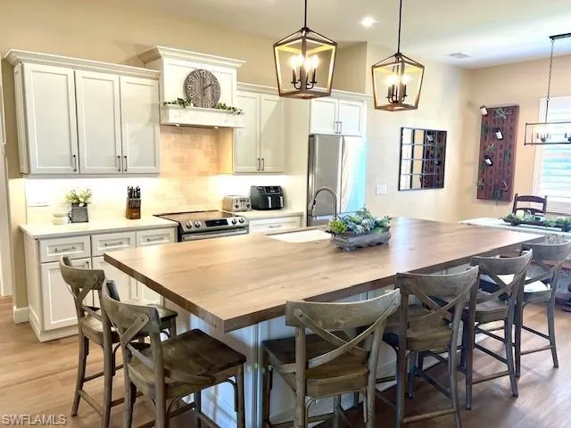 Newly Updated Kitchen with Custom  Wood Cabinetry, White on White Quartz, 10 Foot Island in a Wood like Porcelian. Kohler White Cast Iron Sink, Instahot, New Lighting Fixtures, and New Samsung Appliances
