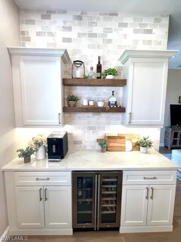 Coffee/Wine Bar with Wine Cooler and neutral subway marble backsplash.