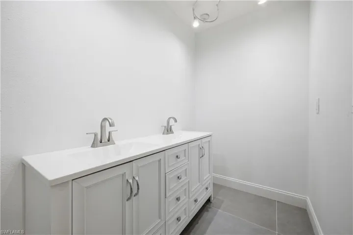 Dual vanity with brushed nickel faucets, white countertop, and integrated sinks
