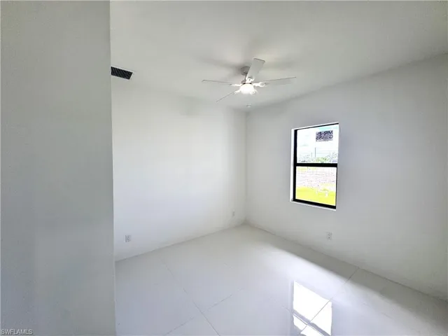 Unfurnished room with light tile patterned floors and a ceiling fan