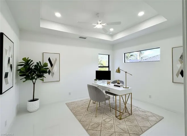 Office area featuring a tray ceiling, ceiling fan, and recessed lighting