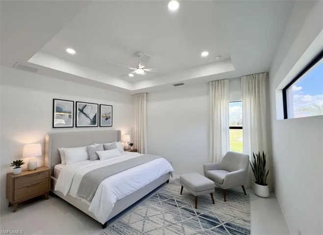 Bedroom featuring a ceiling fan, a tray ceiling, and recessed lighting