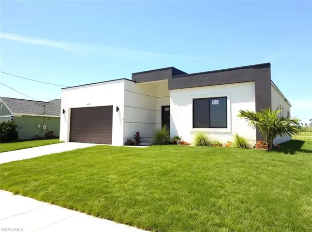 Contemporary home with a front lawn, stucco siding, driveway, and a garage