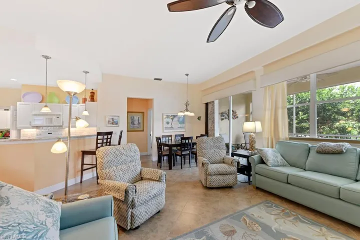 Living room with light tile patterned floors and ceiling fan