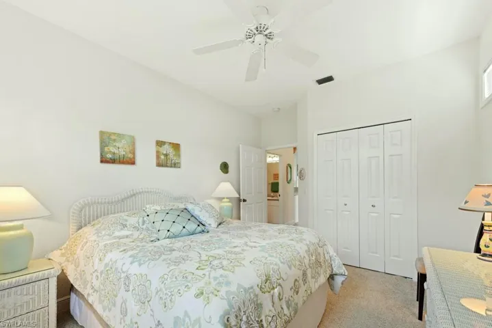 Bedroom with a closet, ceiling fan, and light carpet