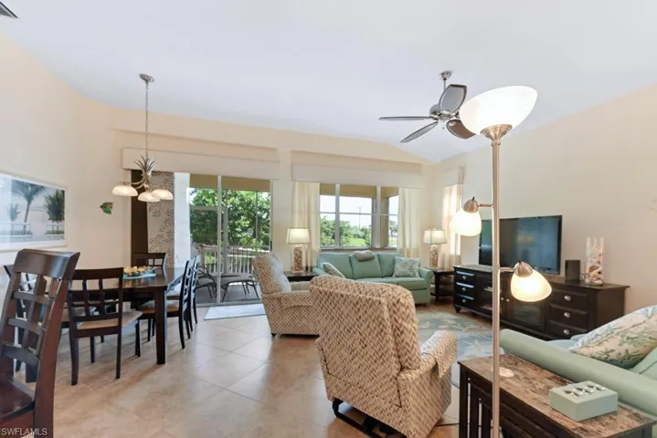 Living room featuring ceiling fan and vaulted ceiling