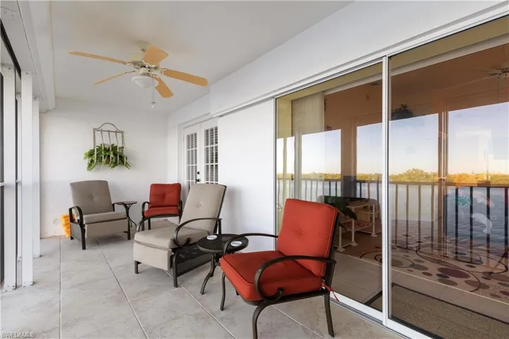 Sunroom featuring a water view and ceiling fan