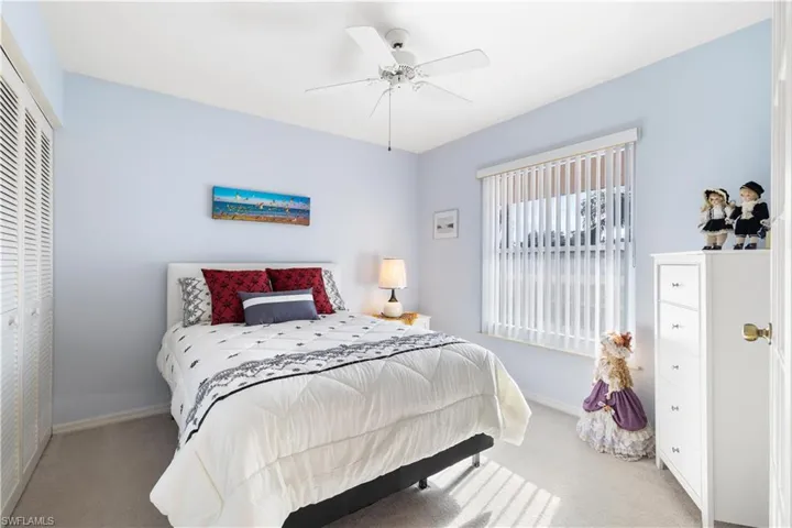 Bedroom with ceiling fan, a closet, and light carpet