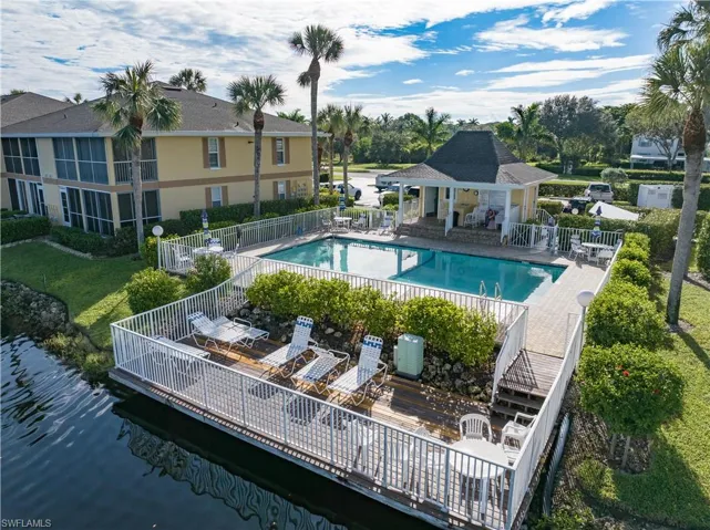 View of pool featuring a patio, a deck with water view, and a yard