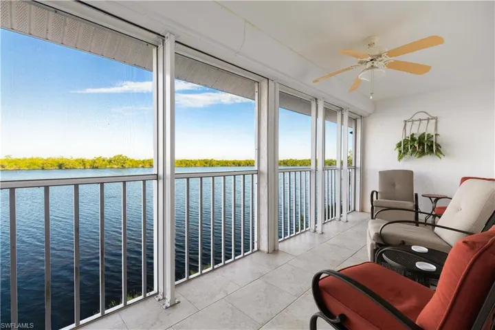 Sunroom featuring a water view and ceiling fan