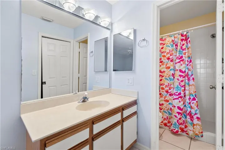 Bathroom featuring vanity, tile patterned flooring, toilet, and a shower with shower curtain