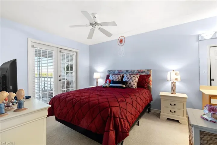 Bedroom featuring french doors, ceiling fan, light colored carpet, and access to exterior