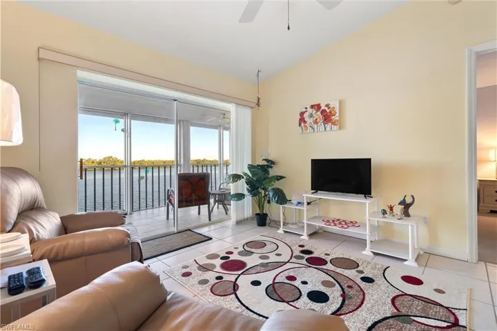 Tiled living room with vaulted ceiling and ceiling fan
