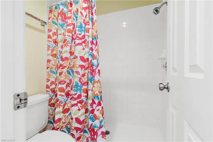 Bathroom with a shower with curtain and toilet