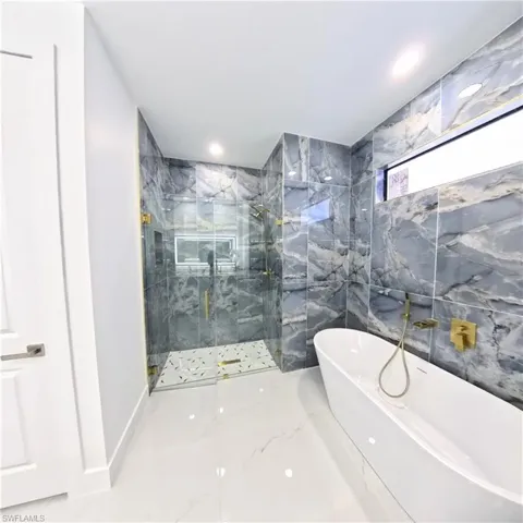 Full bath with a marble finish shower, a soaking tub, recessed lighting, and marble finish floors
