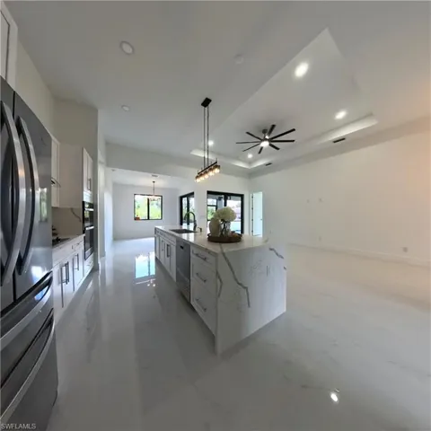 Kitchen featuring appliances with stainless steel finishes, a sink, modern cabinets, white cabinetry, and recessed lighting