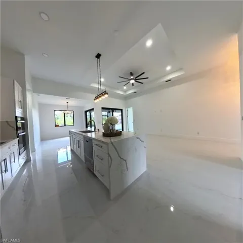Kitchen featuring a sink, white cabinetry, recessed lighting, double oven, and healthy amount of natural light
