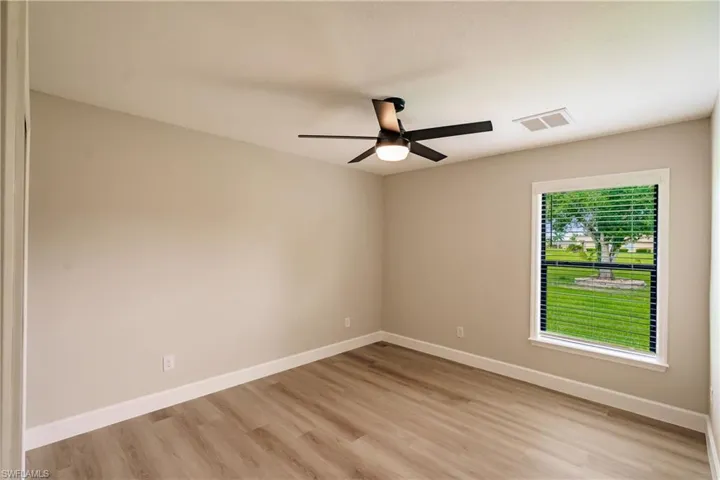Empty room with light hardwood / wood-style flooring and ceiling fan