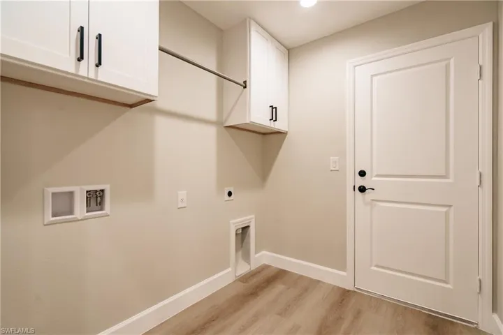 Laundry room featuring cabinets, hookup for an electric dryer, washer hookup, and light hardwood / wood-style floors
