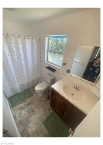 Bathroom featuring tile flooring, toilet, and vanity