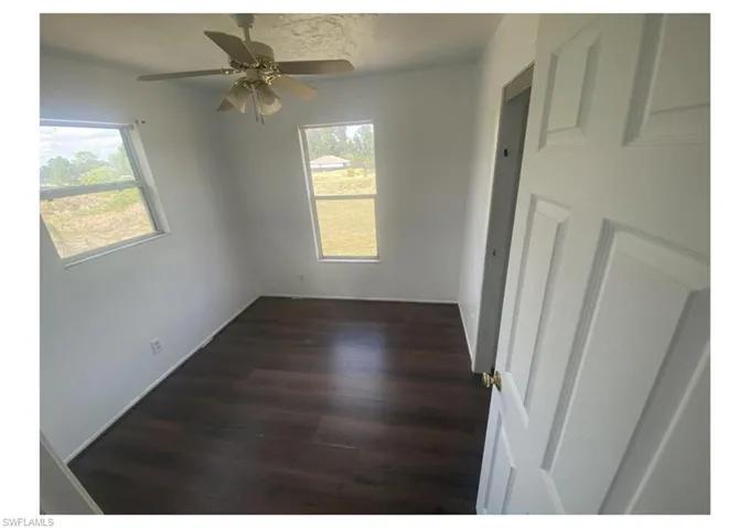 Empty room featuring ceiling fan and hardwood / wood-style flooring