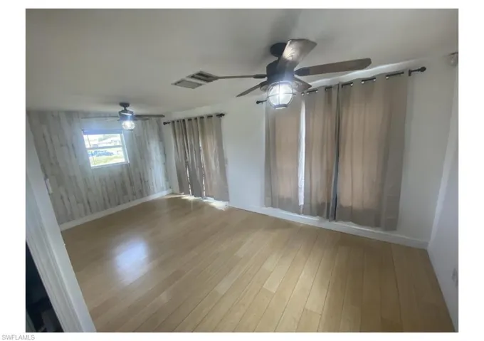 Spare room featuring hardwood / wood-style floors and ceiling fan