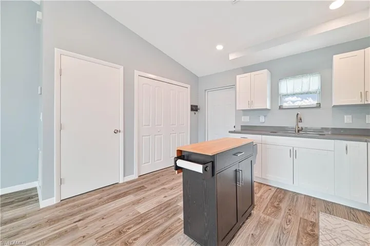 Kitchen featuring sink, white cabinets, and light wood-type flooring