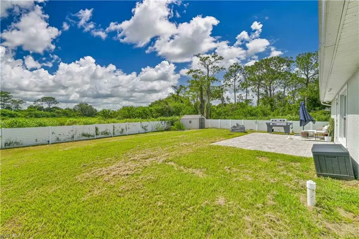 View of yard with a patio and a storage shed