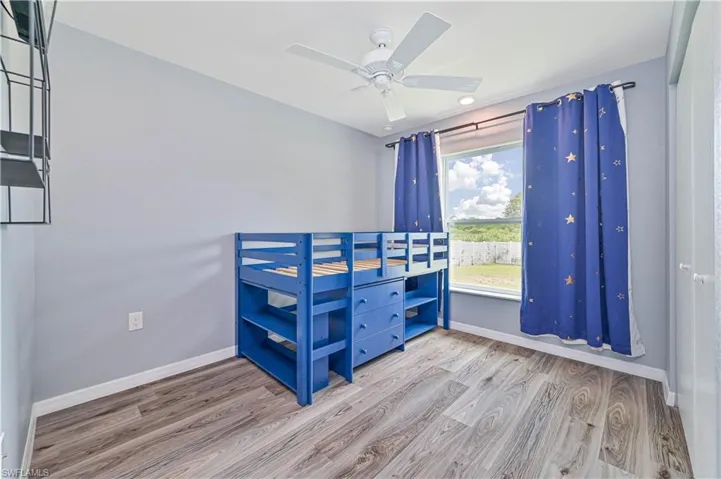 Bedroom featuring hardwood / wood-style floors, ceiling fan, and multiple windows