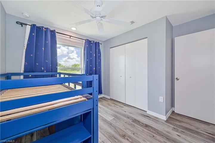 Bedroom with hardwood / wood-style floors, a closet, and ceiling fan