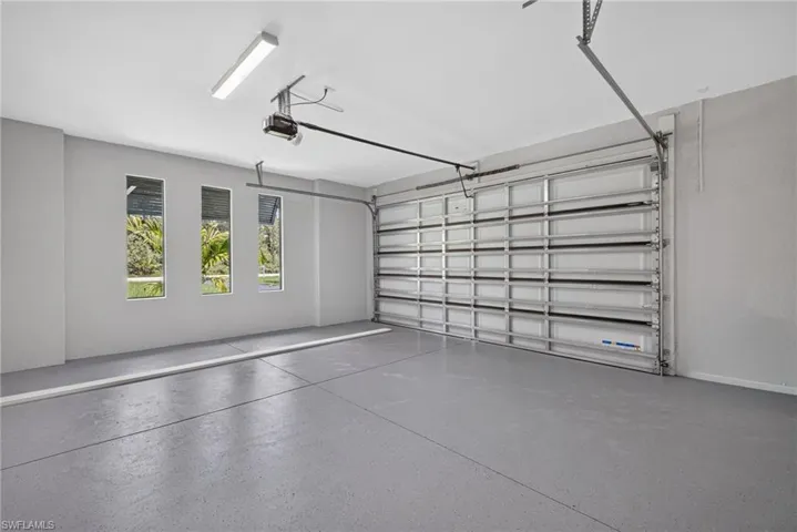 Spacious garage with an automatic overhead door and speckled epoxy flooring