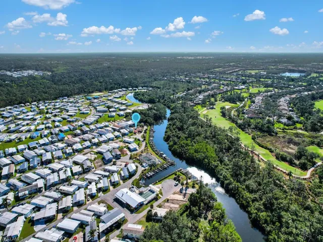 Aerial view of property and surrounding area featuring a nearby body of water and nearby suburban area