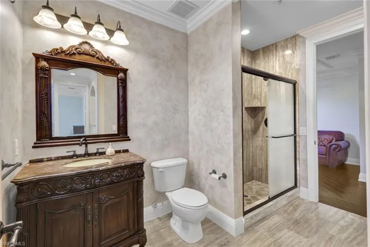 Full bath featuring ornamental molding, vanity, light wood finished floors, a shower stall, and recessed lighting